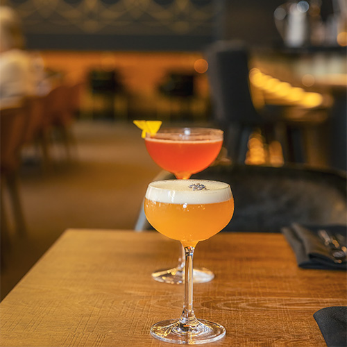 Two colourful cocktails on a table